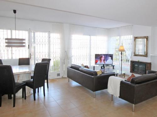 a living room with couches and a table and a television at Holiday Home Mar y Montaña by Interhome in Benidorm