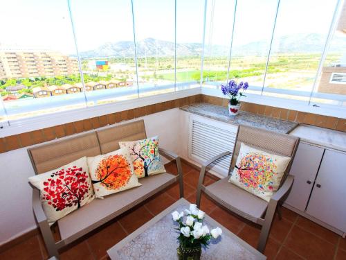El BorseralにあるApartment Jardines del Mar I-1 by Interhomeの椅子2脚と枕、窓が備わる客室です。