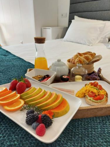 a breakfast tray with fruit on a bed at HOTEL S - ALOJAMENTO LOCAL in Castro Verde