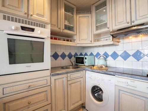 une cuisine avec des armoires blanches et une laveuse et une sécheuse dans l'établissement Studio Le Slalom - Val Claret-5 by Interhome, à Tignes