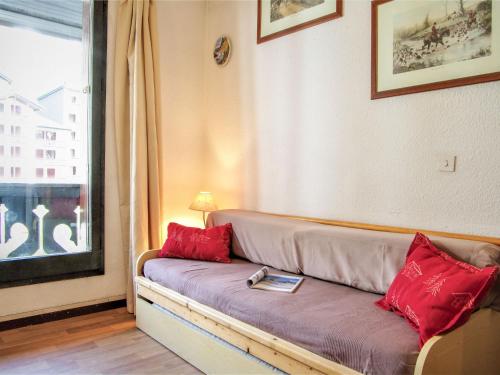 - un canapé avec des oreillers rouges dans une chambre avec une fenêtre dans l'établissement Studio Le Triolet-6 by Interhome, à Chamonix-Mont-Blanc