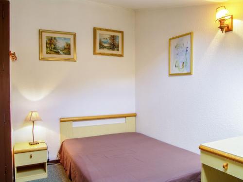 - une chambre avec un lit et deux photos sur le mur dans l'établissement Studio Le Triolet-6 by Interhome, à Chamonix-Mont-Blanc