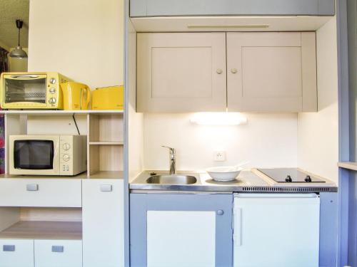 eine kleine Küche mit einer Spüle und einer Mikrowelle in der Unterkunft Studio Gentiane-5 by Interhome in Chamonix-Mont-Blanc