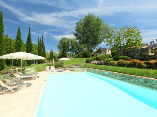a large swimming pool with a patio and a garden at Apartment Forno by Interhome in Rapolano Terme