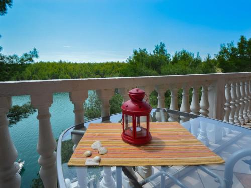 a red lantern sitting on a wooden table on a balcony at Apartment Mara-2 by Interhome in Anić