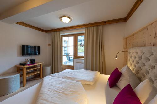 a hotel room with a bed and a window at Hotel und Alpen Apartments mit Sauna - Bürglhöh in Bischofshofen