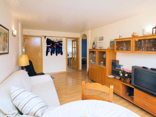 sala de estar con sofá blanco y TV en Apartment Mariola by Interhome, en Sant Andreu de Llavaneres