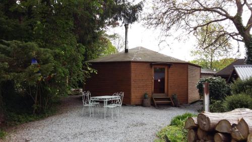 a small shed with a table and chairs in front of it at Domaine De La Carrauterie by Terre Insolite in Sautin