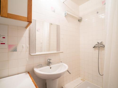 une salle de bain blanche avec un lavabo et une douche dans l'établissement Apartment Les Lauzes C19 by Interhome, aux Menuires