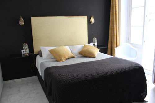 a bedroom with a bed with two yellow pillows at Luxury apartament in Cádiz