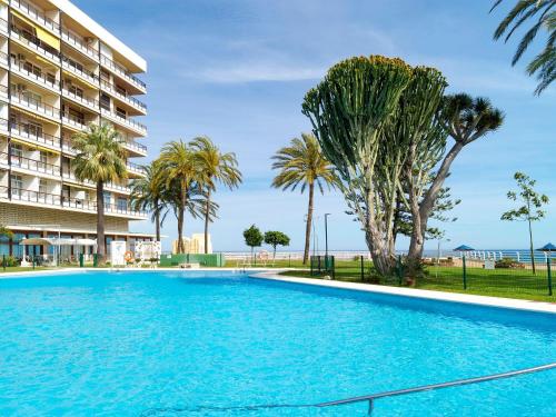 ein Swimmingpool mit Palmen und einem Gebäude in der Unterkunft Apartment Castillo de Santa Clara-1 by Interhome in Torremolinos