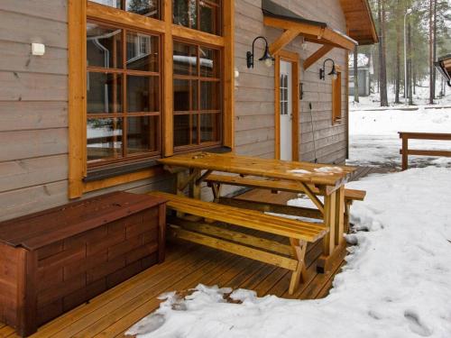 a wooden porch with a bench and a table on a cabin at Holiday Home Kivalonmaa a by Interhome in Äkäslompolo