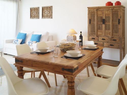 ein Esszimmer mit einem Holztisch und weißen Stühlen in der Unterkunft Apartment Lomas de Los Monteros by Interhome in Marbella