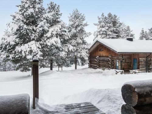 een blokhut in de sneeuw met bomen bij Holiday Home Vuokatinportti a 12 by Interhome in Lahdenperä
