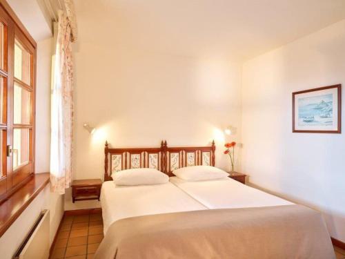 Castillo de AroにあるApartment Resort Hapimag Mas Nou by Interhomeの窓付きの客室の白いベッド1台