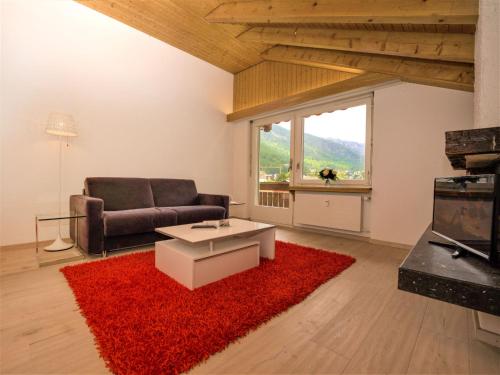 a living room with a couch and a red rug at Apartment Granit-5 by Interhome in Zermatt
