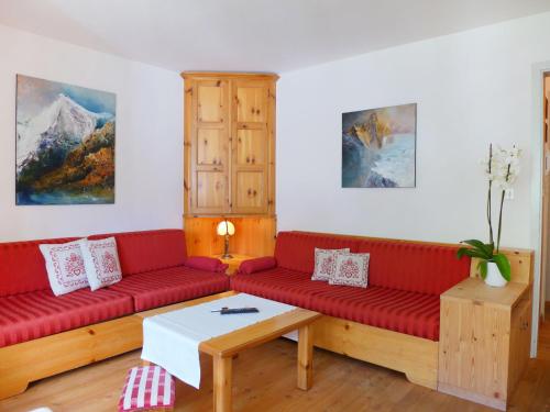 サンモリッツにあるApartment Chesa Arlas D2 by Interhomeのリビングルーム(赤いソファ、テーブル付)