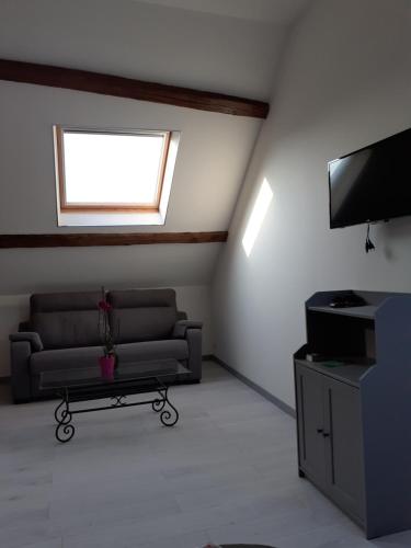 a living room with a couch and a television at LA BONNE ADRESSE 