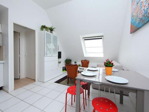 Il dispose d'une cuisine et d'un salon avec une table et des chaises rouges. dans l'établissement Apartment La Guillaumière-1 by Interhome, à Cabourg