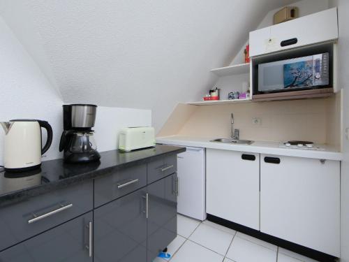 une cuisine avec un évier et un micro-ondes dans l'établissement Apartment La Guillaumière-1 by Interhome, à Cabourg
