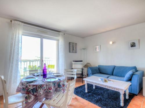 a living room with a blue couch and a table at Apartment les Terrasses du Cap by Interhome in Capbreton