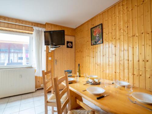 uma sala de jantar em madeira com uma mesa e uma televisão em Apartment Les Lauzes-5 by Interhome em Les Menuires