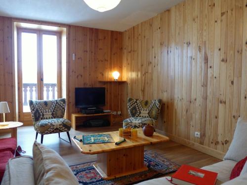 a living room with a couch and a table and a tv at Apartment Chalet Le Tour by Interhome in Chamonix