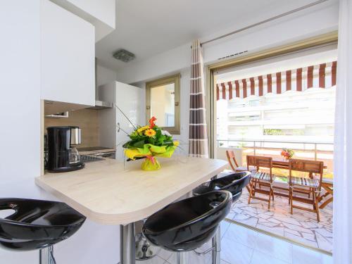une cuisine avec un comptoir avec des chaises et une table avec des fleurs dans l'établissement Apartment Villa Lerins-6 by Interhome, à Cannes