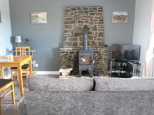 a living room with a stone fireplace and a couch at Holiday Home Flo Anndra by Interhome in Kilmaluag
