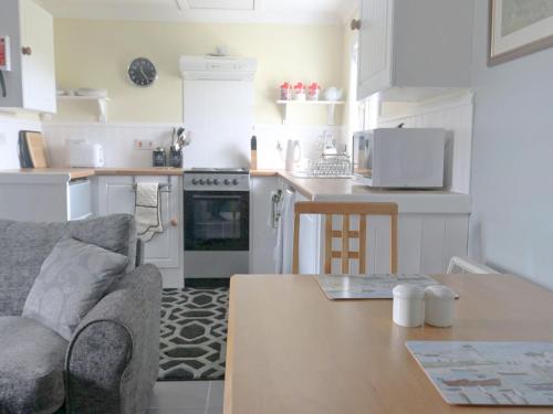 cocina y sala de estar con sofá y mesa en Holiday Home Flo Anndra by Interhome, en Kilmaluag