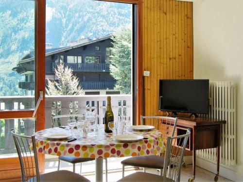 - une table à manger avec une bouteille de vin et des chaises dans l'établissement Apartment Le Brévent-22 by Interhome, à Chamonix-Mont-Blanc