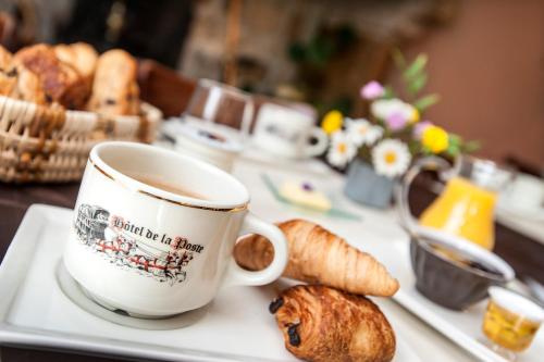 a tray with a cup of coffee and some pastries at Logis Hôtel Restaurant de la Poste et La Grange Détente, espace bien-être in Châteauneuf-de-Randon