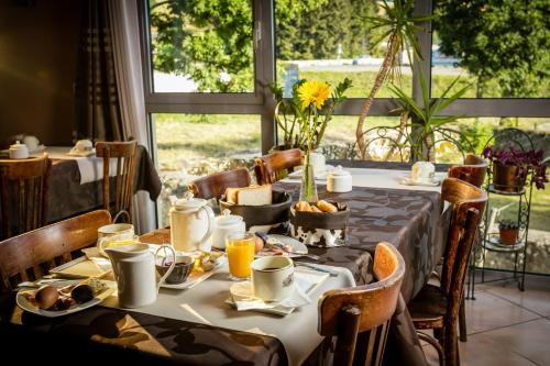 a table set for breakfast in a room with a window at Logis Hôtel Restaurant de la Poste et La Grange Détente, espace bien-être in Châteauneuf-de-Randon