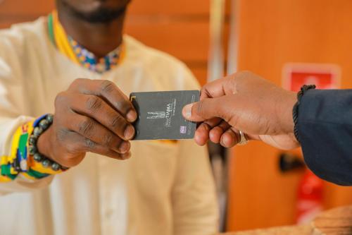 a person is handing another person a wallet at Hotel Tiama Abidjan in Abidjan