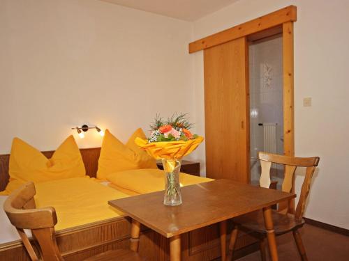 ein Wohnzimmer mit einem Tisch und einem gelben Sofa in der Unterkunft Apartment Berneckblick by Interhome in Kauns