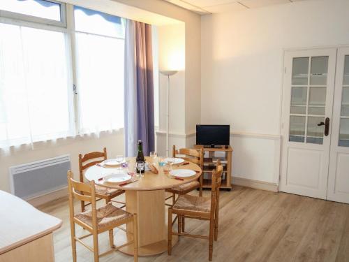 une salle à manger avec une table, des chaises et une télévision dans l'établissement Apartment Le Petit Robinson-4 by Interhome, à La Richardais