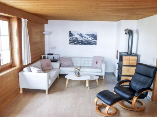 ein Wohnzimmer mit einem Sofa und einem Tisch in der Unterkunft Holiday Home Chalet Reinhysi by Interhome in Grindelwald