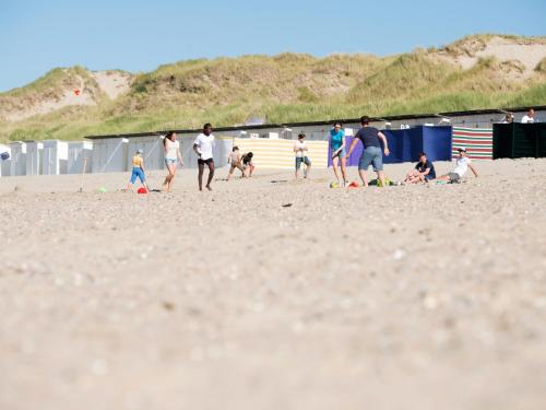 MispelburgにあるApartment Zen aan Zeeの浜辺でサッカーをしている人々の集団