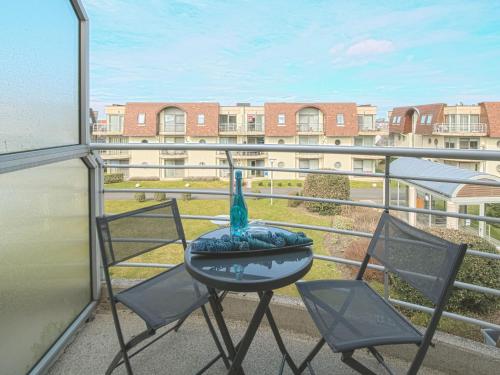 - un balcon avec 2 chaises et une table avec un vase dans l'établissement Apartment Blutsyde Promenade-26 by Interhome, à Mispelburg