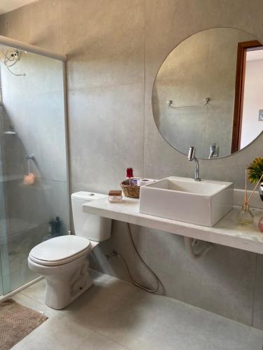 uma casa de banho com um WC, um lavatório e um espelho. em Recanto da Barra Chalé em Barra Grande