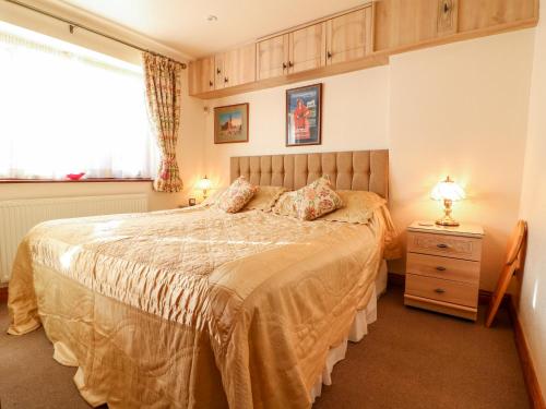 a bedroom with a large bed and a window at Maple Apartment in Cheltenham