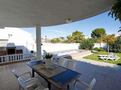 a patio with a table and chairs and a pool at Holiday Home Sandra by Interhome in Riumar