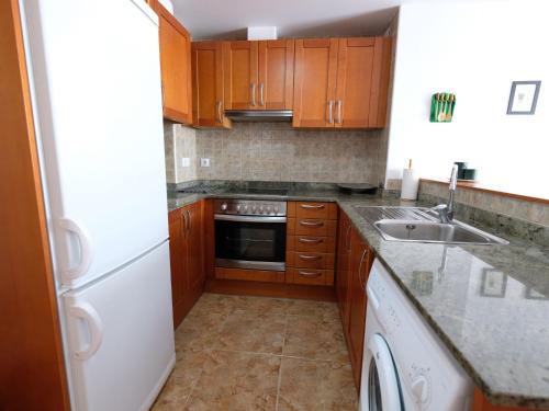 małą kuchnię z drewnianymi szafkami i zlewem w obiekcie Apartment Simanca by Interhome w mieście Sant Carles de la Ràpita