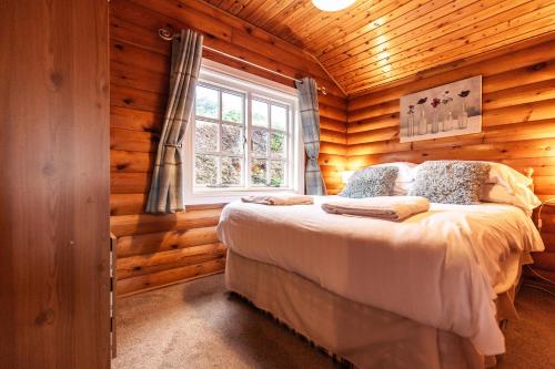 a bedroom with a bed in a log cabin at 3 Bedroom Log Cabin in Snowdonia nr MTB trails in Tanygrisiau