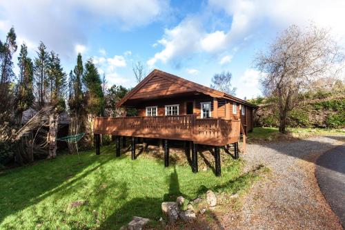 a house on wooden posts in the grass at 3 Bedroom Log Cabin in Snowdonia nr MTB trails in Tanygrisiau