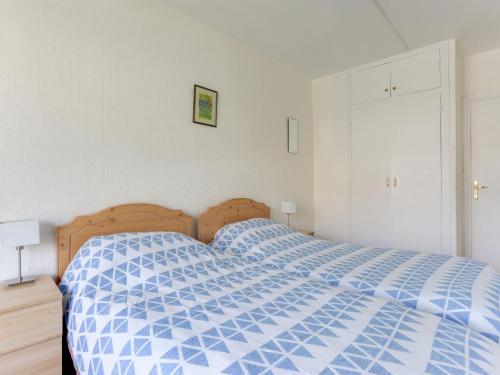 ein Bett mit blauer Decke in einem Schlafzimmer in der Unterkunft Apartment Le Bec Rouge - Le Lac-5 by Interhome in Tignes
