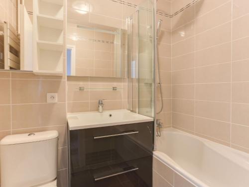 een badkamer met een wastafel, een toilet en een bad bij Apartment Le Bec Rouge - Le Lac-5 by Interhome in Tignes