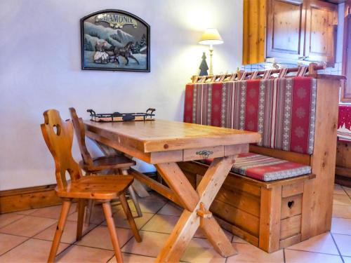 een houten tafel met een bank en een stapel boeken bij Apartment Ginabelle 1-1 by Interhome in Chamonix-Mont-Blanc