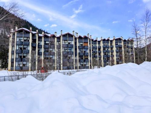 duży budynek apartamentowy ze śniegiem przed nim w obiekcie Apartment Grand Roc-4 by Interhome w Chamonix-Mont-Blanc