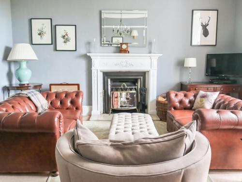 a living room with leather furniture and a fireplace at Holiday Home Dunvegan House by Interhome in Dunvegan